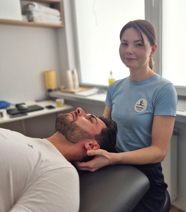 Fizjoterapeuta Be Active prowadzi terapię manualną odcinka szyjnego kręgosłupa pacjenta w gabinecie rehabilitacyjnym.