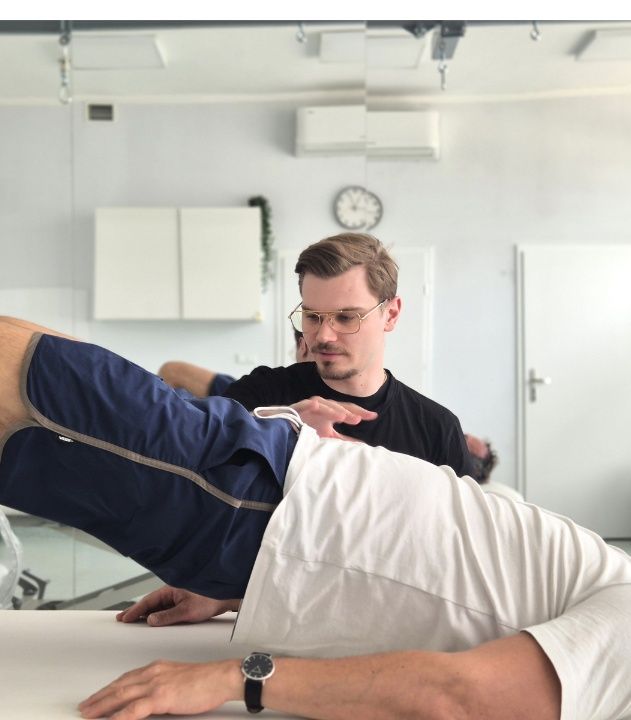 Fizjoterapeuta urologiczny sprawdza pracę mięśni dna miednicy  podczas konsultacji urologicznej.